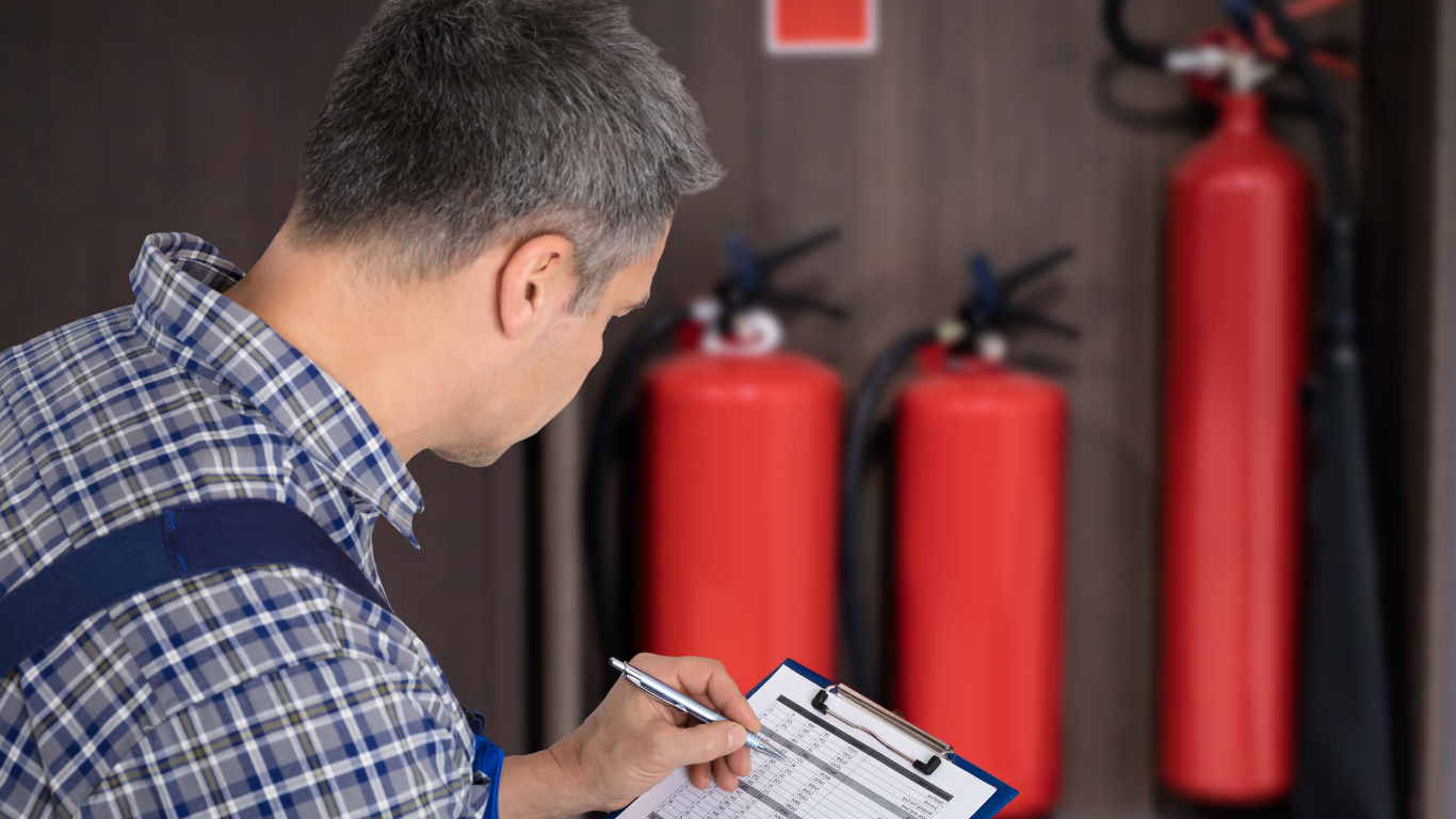 Technician inspecting a fire extinguisher to ensure functionality and compliance